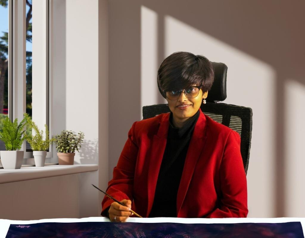 Madhubanti Mukherjee at her studio desk, brush in hand, working on a watercolor