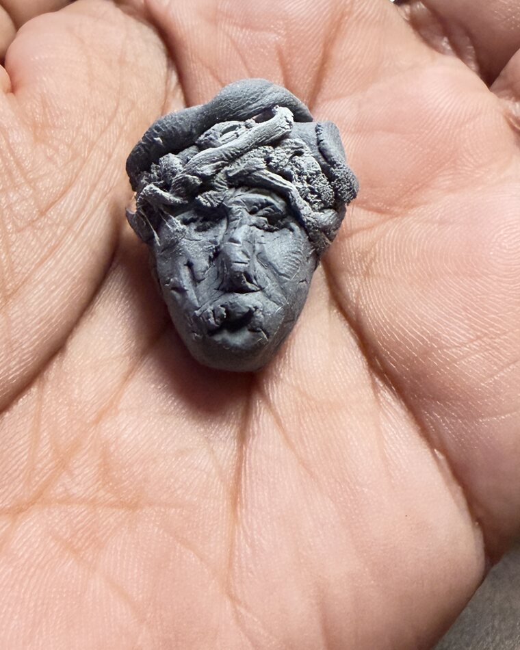 A face, cradled in the palm — soon to be folded back into grey