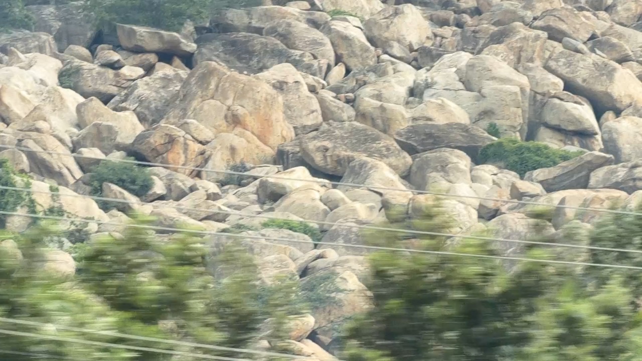 Boulder-strewn granite hills seen close from the road.